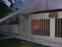 Unter Atemschutz kämpfen sich die Feuerwehrleute im Gebäudeinneren vor